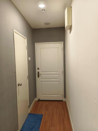 a hallway with a white door and a blue rug at JJ's Modern Suite Kampar- Near UTAR in Kampar