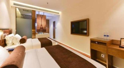 a hotel room with a bed and a tv at James Joyce Coffetel Shijiazhuang the Mixc Jinyuan Tower Airport Bus in Shijiazhuang