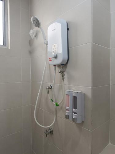 a shower in a bathroom with a blow dryer at Jedi Homestay in Kajang