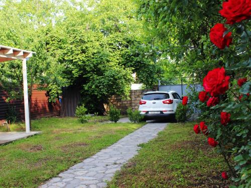 a white car parked in a yard with red roses at Soft Villa in Gabala
