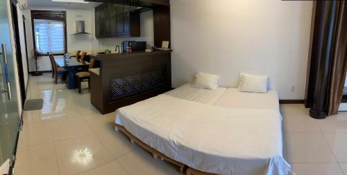 a bedroom with a large bed and a kitchen at SOCHU HOUSE- Tuần Châu Homestay & Coffee in Ha Long