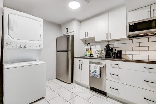 a kitchen with white cabinets and a stainless steel refrigerator at Luxury & private 3 bed basement unit kitchen, wifi, park, mall in London