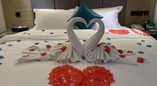 two swans made out of confetti on a bed at Borrman Hotel Huizhou West Lake Shuidong Street in Huizhou