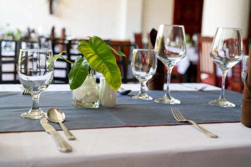 a table with four wine glasses and silverware on it at SIEM REAP RIVER VIEW Residence in Siem Reap