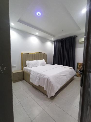 a bedroom with a large bed with white sheets at 1 Bedroom Apartment - Ikeja in Ikeja