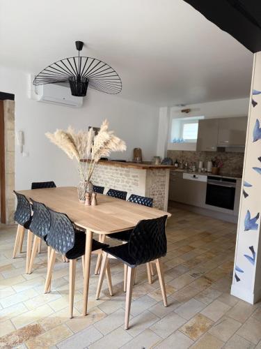 une cuisine et une salle à manger avec une table et des chaises en bois dans l'établissement Le Nid de Plumetot - Maison de Charme en Normandie, à Plumetot