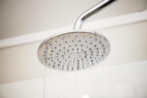 a shower with a metal shower head in a bathroom at Nightcap at Jamison Hotel in Penrith