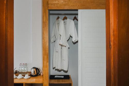 a closet with white clothes hanging on a rack at SIEM REAP RIVER VIEW Residence in Siem Reap
