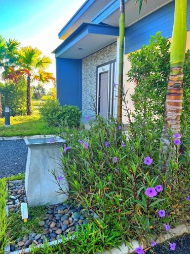 a blue house with flowers in front of it at Blue Moon Boutique Resort in Sichon
