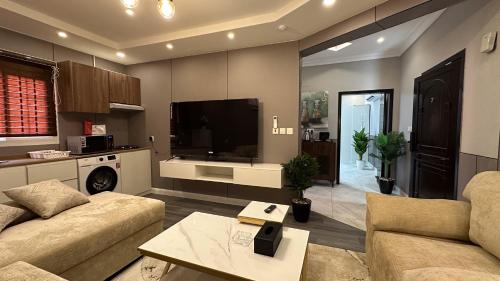 a living room with a couch and a tv at شقة مودرن فخمة غرفة نوم وصالة in Jeddah