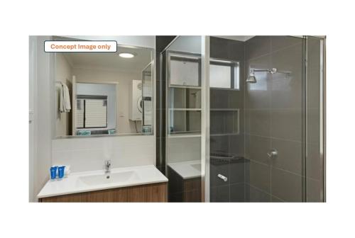 a bathroom with a sink and a shower with a mirror at Discovery Parks - Alice Springs in Alice Springs