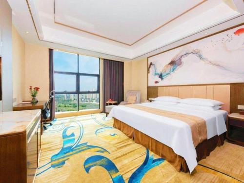 a bedroom with a large bed and a large window at Venus Royal Hotel Nanning East High-Speed Railway Station in Nanning