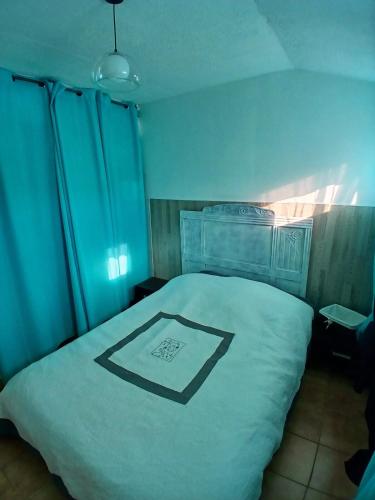 une chambre avec un lit blanc avec une image noire dessus dans l'établissement Maison en Provence, à Istres