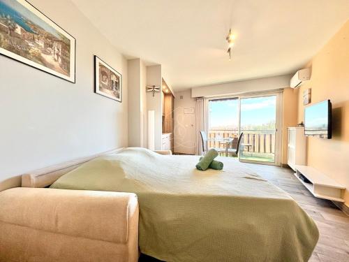 - une chambre dotée d'un grand lit avec un ours en peluche dans l'établissement Le Beauséjour, studio with pool, parking, air conditioning, au Cannet