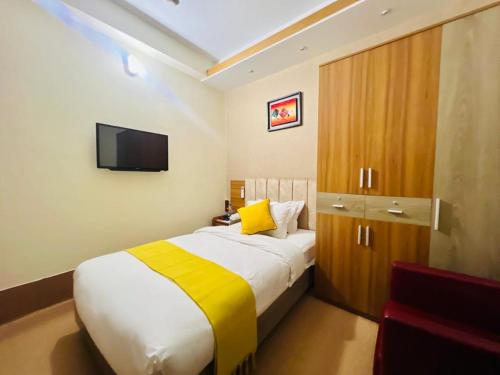 a bedroom with a large bed and a television at Hotel Taj Metro in Maulvi Bāzār