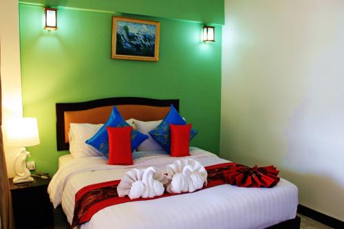 a bedroom with a large bed with red and blue pillows at Namkhong Riverside in Chiang Khong