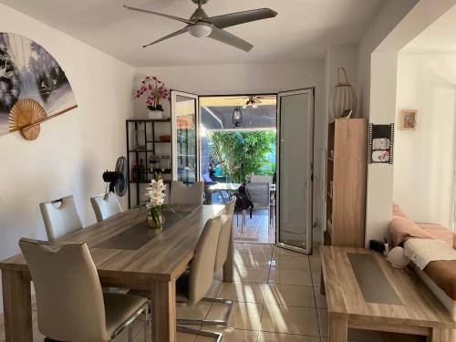 a dining room with a wooden table and chairs at Chez NOUS Bis in Saint-Paul
