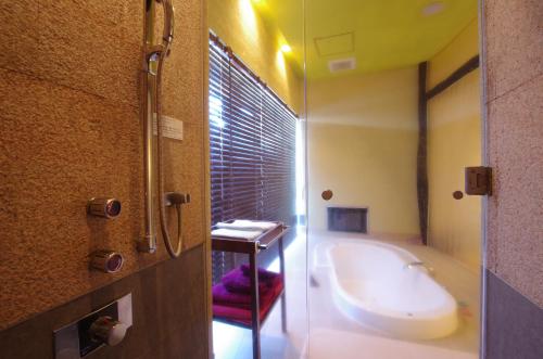 a bathroom with a bath tub and a sink at Blue Hotel NAGI-Adult Only in Otaru