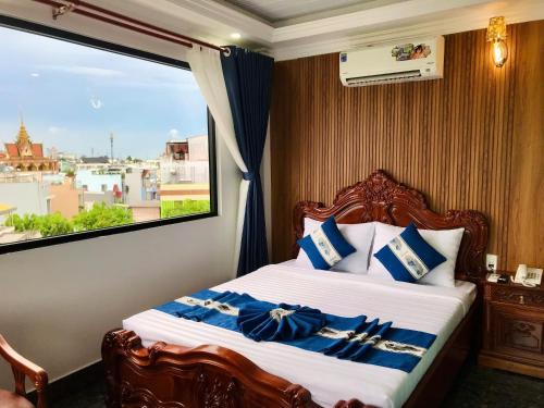 a bedroom with a bed with a large window at Cozy 86 Homestay in Can Tho
