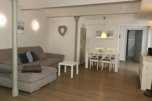 a living room with a couch and a table at Gut Kuhfs in Großzössen