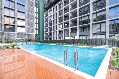 a swimming pool in front of a building at 2BR apartment close to Accor Stadium in Sydney