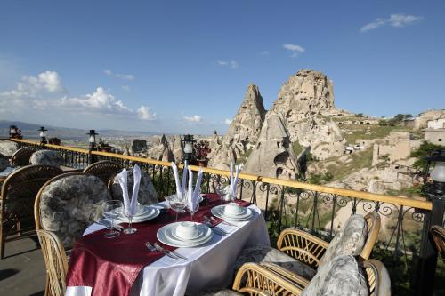 a table on a balcony with a view of rocks at Hermes Cave Hotel in Uçhisar