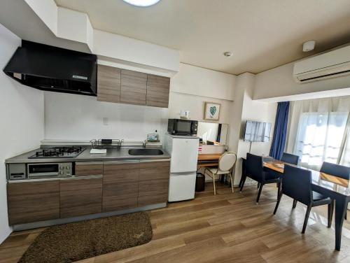 a kitchen with a stove and a table with chairs at To-Be in Nagoya