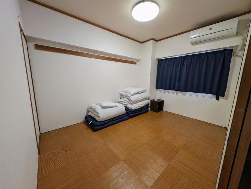 a room with two beds in it with a window at To-Be in Nagoya