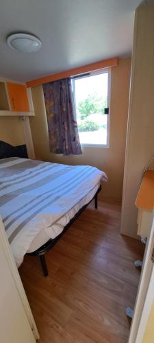 une chambre avec un lit et une fenêtre dans l'établissement Camping les Galets, à Banassac