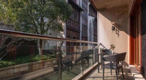 a porch with a table and chairs on a balcony at Eden Club House in Tongxiang