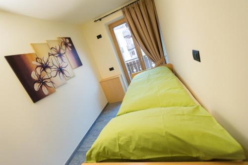 リヴィーニョにあるChalet Luxe Livignoの窓付きのベッドルーム1室(緑色のベッド1台付)
