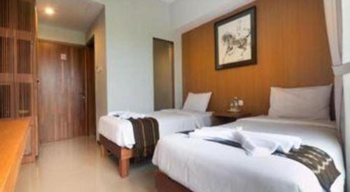 a hotel room with two beds in a room at Hadi Poetra Hotel in Kuta