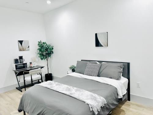 a white bedroom with a bed and a table at Modern New Studio Cozy&Prime Location in North Sherman Way