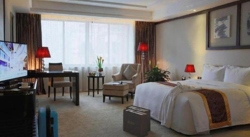 a hotel room with a large bed and a desk at SUN Yat-sen university Hotel and Conference Centre in Guangzhou