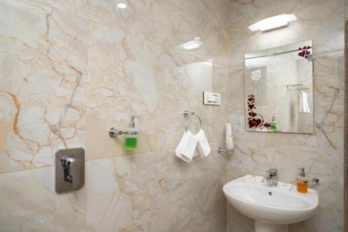 a white bathroom with a sink and a mirror at 5bhk Villa Near Caldolium Beach Goa in Candolim