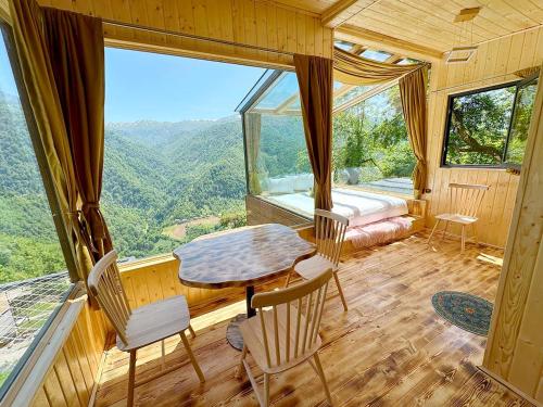 a room with a table and chairs and a large window at Eco House Merisi in Merisi