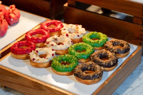 a tray of donuts with different toppings on them at Hyatt Regency Hengqin-Free shuttle bus to Chimelong Ocean Kingdom & Hengqin Port in Zhuhai