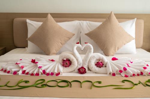 a bed with two swans made to look like hearts at SIEM REAP RIVER VIEW Residence in Siem Reap