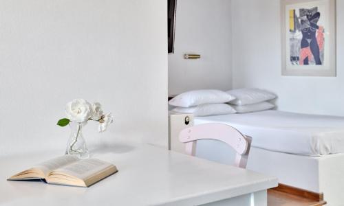 a table with a book and a vase with a flower at Aeolos Hotel & Villas - Pelion in Chorefto