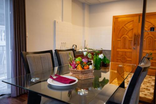 a glass table with a basket of fruit on it at SIEM REAP RIVER VIEW Residence in Siem Reap