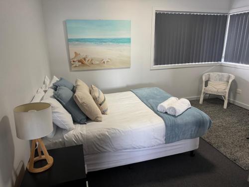 a bedroom with a bed and a table with a lamp at Bircoo Cottage in Bridport