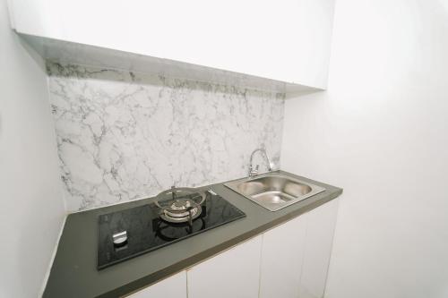 a kitchen counter with a sink and a stove at Marina Villa 1 in Yogyakarta