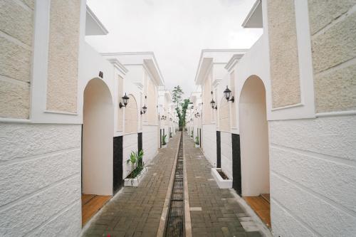 an empty alleyway between two white buildings at Marina Villa 1 in Yogyakarta