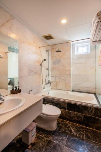 a bathroom with a toilet and a sink and a tub at Tarasa Hotel by Elite24 in Danang