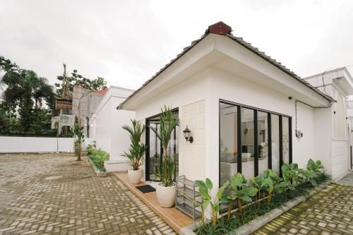 a white house with plants in front of it at Marina Villa 1 in Yogyakarta