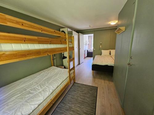 a bedroom with two bunk beds and a hallway at Hällestrand Semesterby R12 in Strömstad