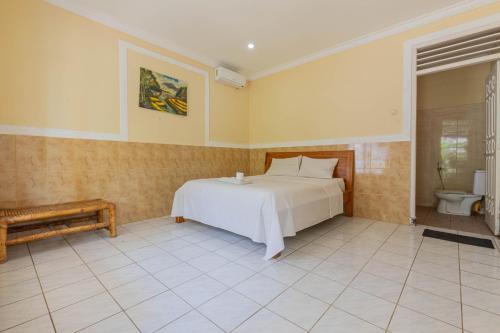 Funny Homestay 2 في غيلي تراوانغان: غرفة نوم بسرير ابيض ودورة مياه