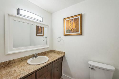a bathroom with a sink and a mirror and a toilet at Portland Charming Home in Portland