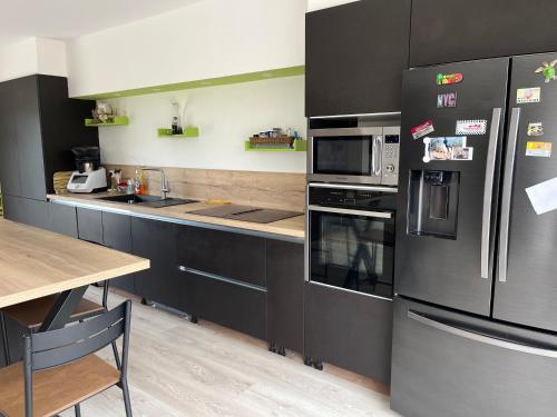 une cuisine avec des armoires noires et des appareils en acier inoxydable dans l'établissement Entre mer et montagne, à Garéoult