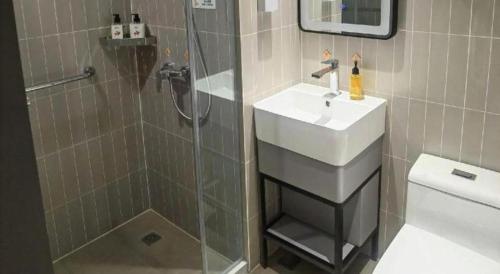 a bathroom with a sink and a shower and a toilet at Jinjiang Inn Tianjin Station Jinwan Square in Tianjin